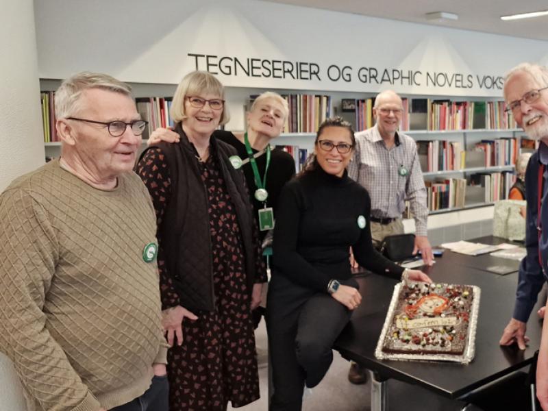 Gruppe af bibliotekets frivillige stående omkring et bord i bibliotekets østsal.